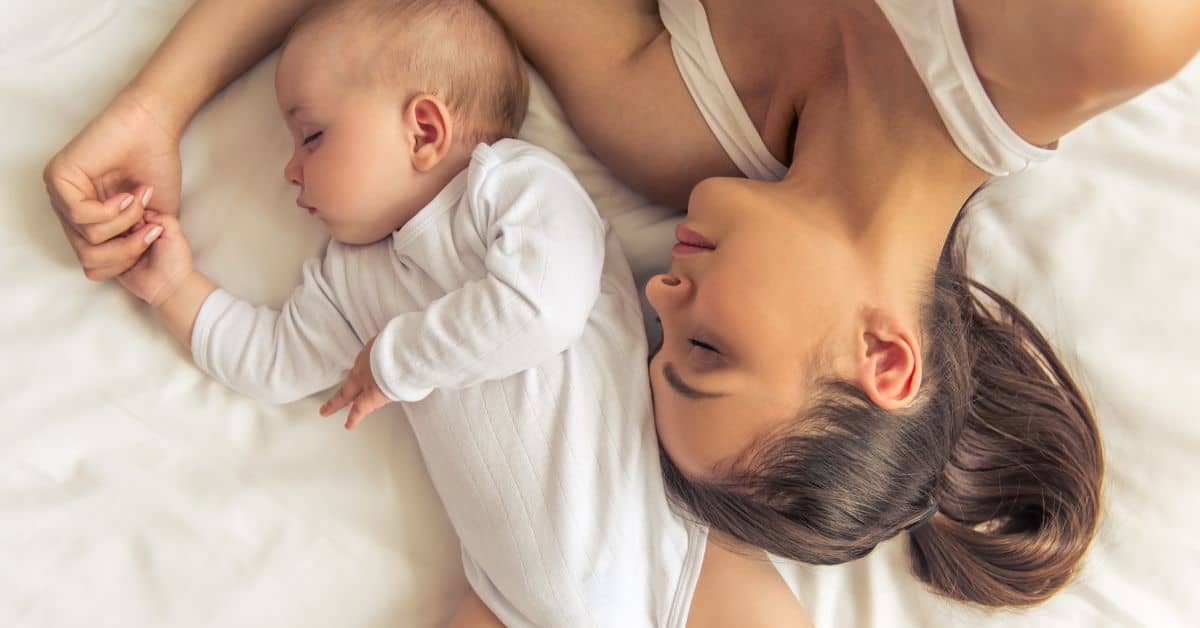 Mom sleeping next to her baby